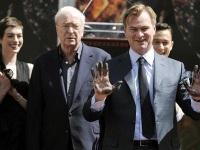Nolan muestra sus manos sucias del cemento luego de dejar sus huellas. Atrás Michael Caine, Joseph Gordon Levitt y Anne Hathaway celebran